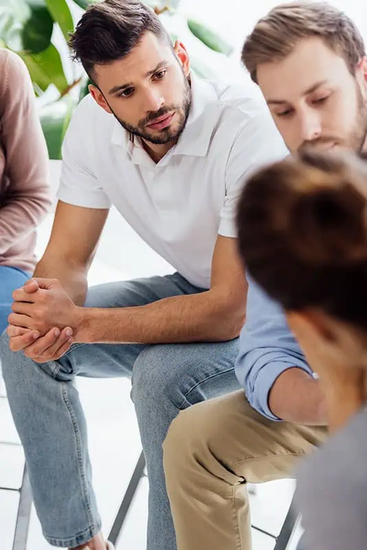 People participate in group therapy at a drug rehab.