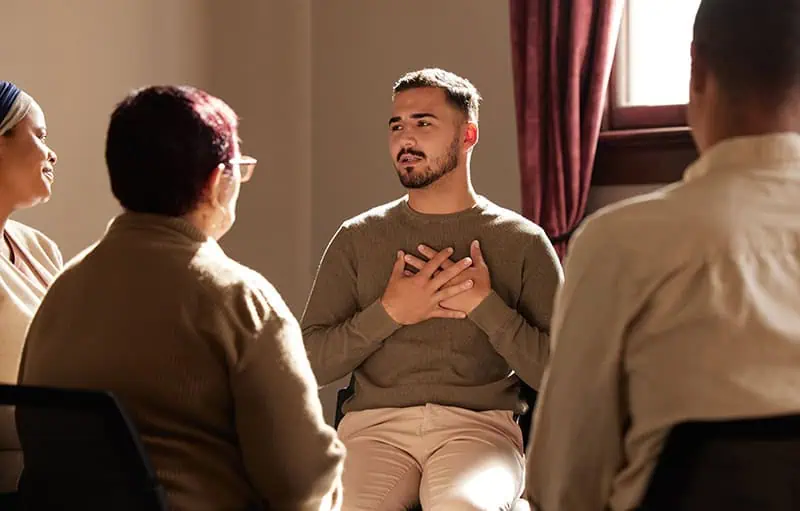 People participate in group therapy at a drug rehab.